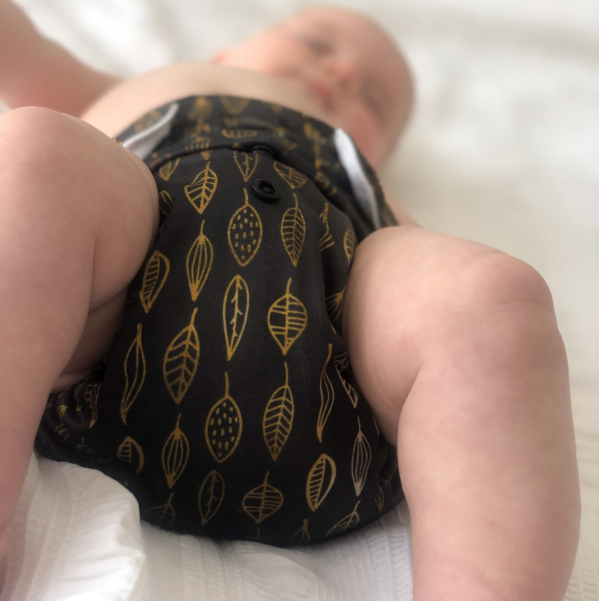 Leaves cloth nappy. Image shows a close up of a baby wearing their leaves cloth nappy